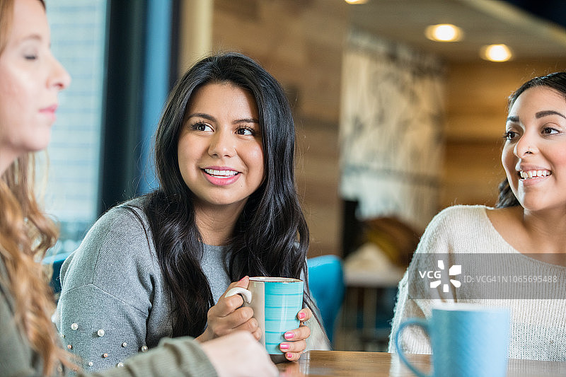 女朋友们在咖啡店里欢笑，享受彼此的陪伴图片素材