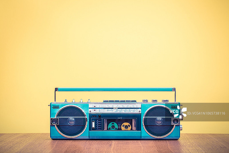 80年代的复古过时便携式薄荷绿色立体声收音机卡带录音机，黄色背景。老式复古风格滤镜照片图片素材
