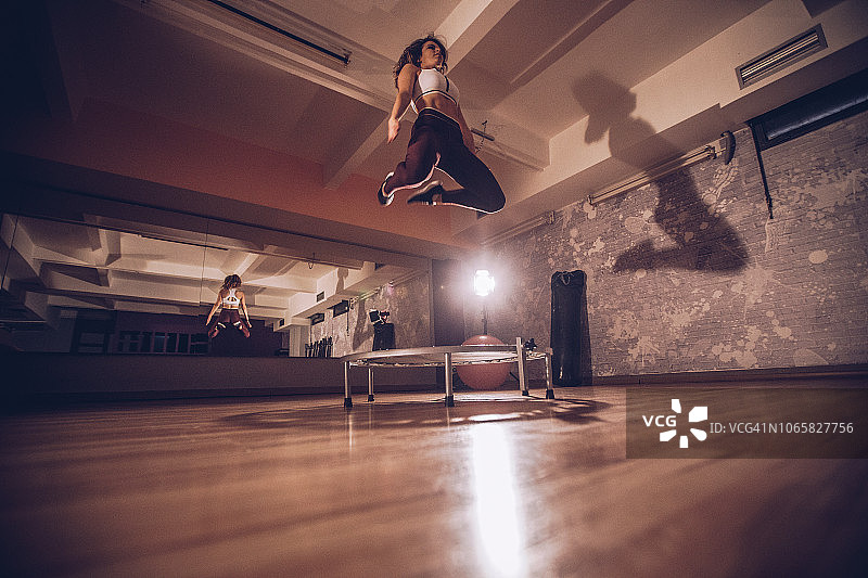 年轻女子在蹦床上锻炼图片素材