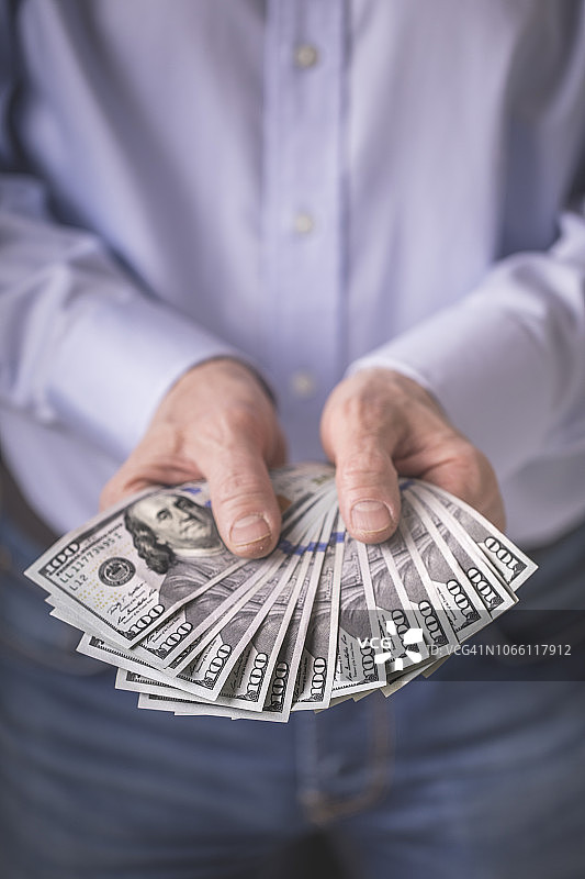 男人手中拿着的美国一百美元钞票图片素材
