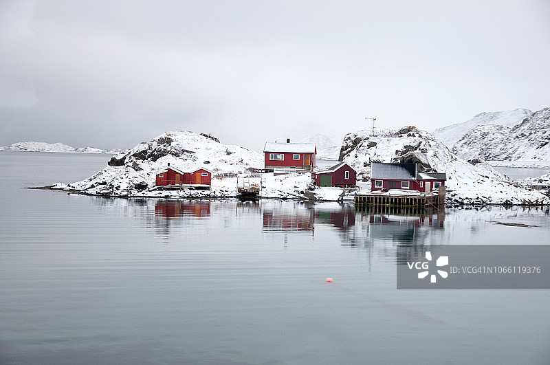 挪威北部北角附近的水域海湾和红色木制传统高脚屋图片素材