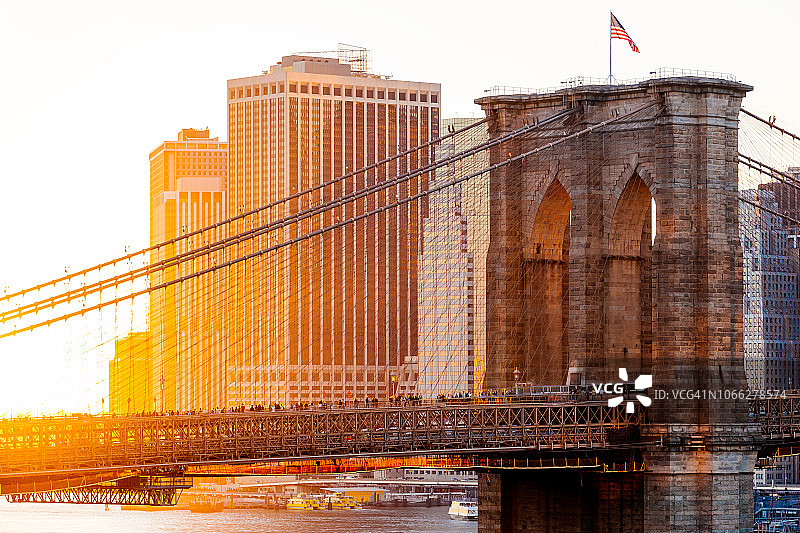 布鲁克林大桥和美国国旗，背景是纽约市中心图片素材