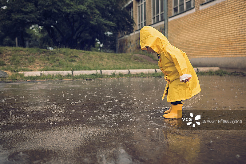 可爱的小男孩在雨天玩耍图片素材