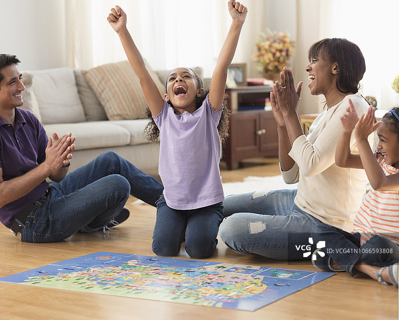 多民族家庭在家中地板上玩拼图图片素材