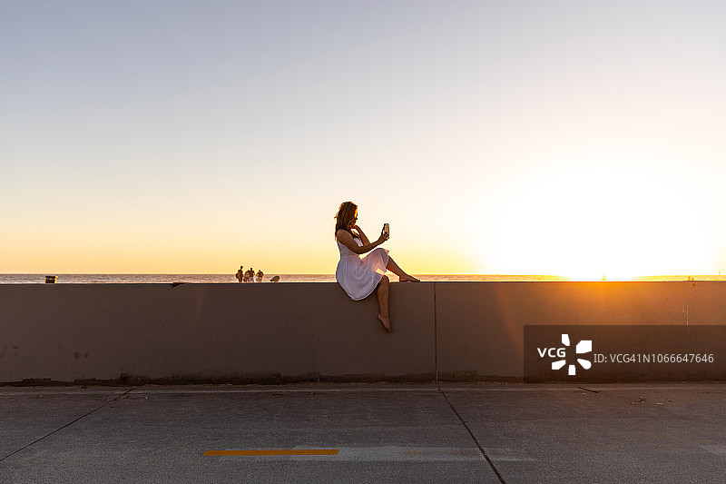 年轻女子在加利福尼亚州威尼斯沙滩上放松图片素材