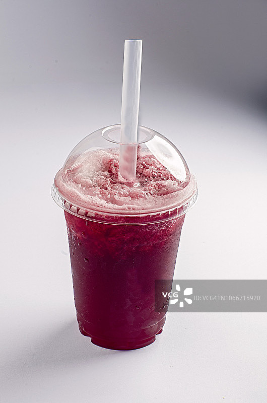 一杯西瓜冰沙，旁边放着一块水果图片素材