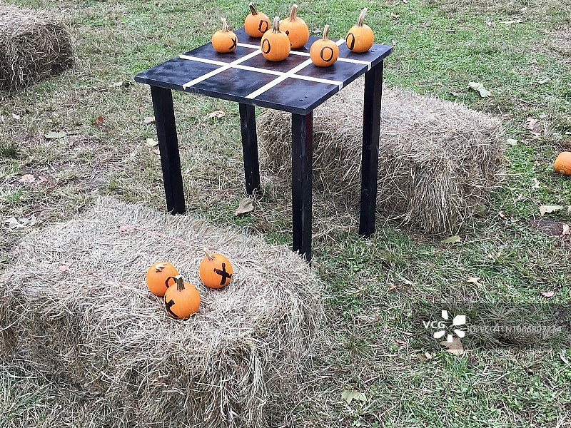 草地上干草捆装饰的南瓜井字棋游戏图片素材