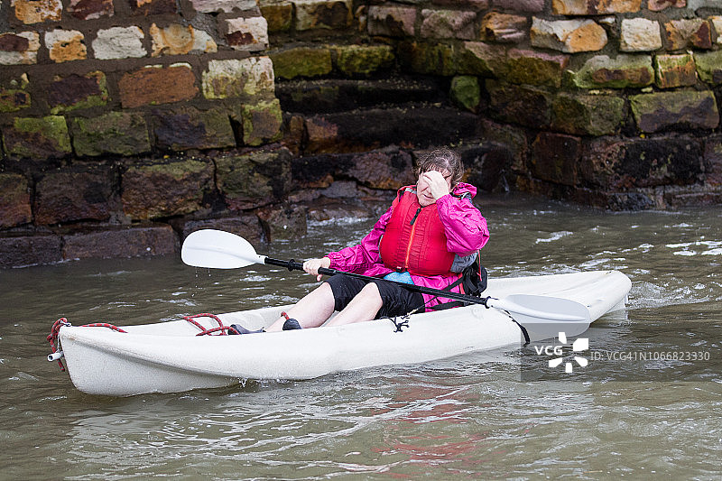 一位中年妇女划着皮划艇图片素材