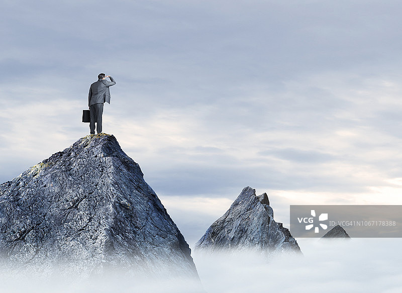商人站在山顶眺望远方图片素材