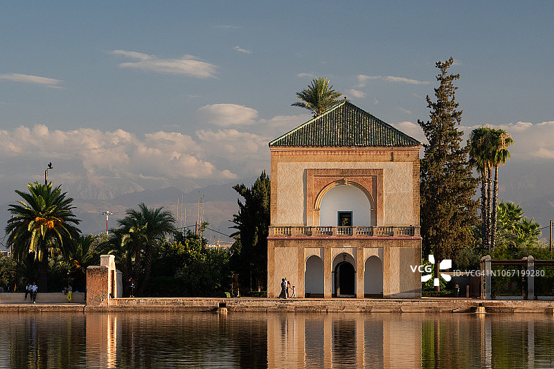 马拉喀什梅纳拉花园凉亭及其在湖中倒影的傍晚金色光辉图片素材