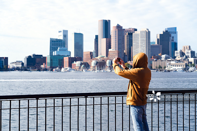 纽约市布鲁克林：在海滨使用手机的男人图片素材