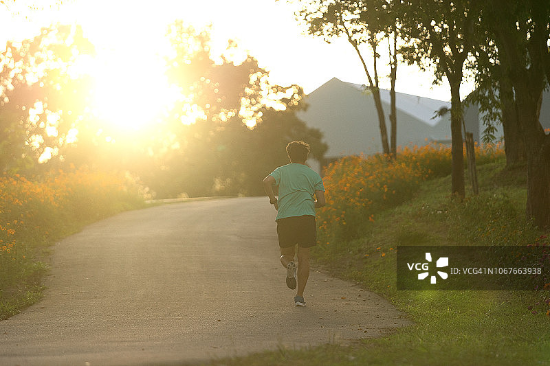 亚洲运动型男子在乡村和日落时慢跑和锻炼图片素材