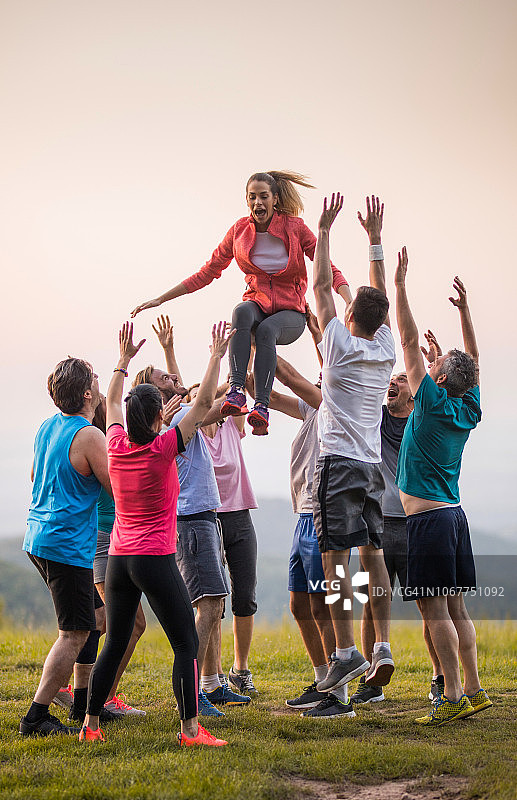 一群运动员将女性朋友高高抛向空中图片素材