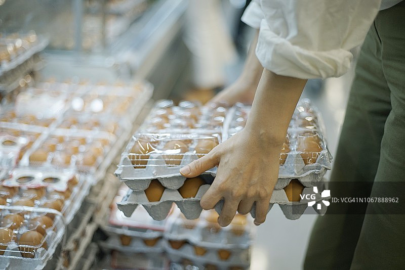 女人在超市里拿着一盒鸡蛋图片素材