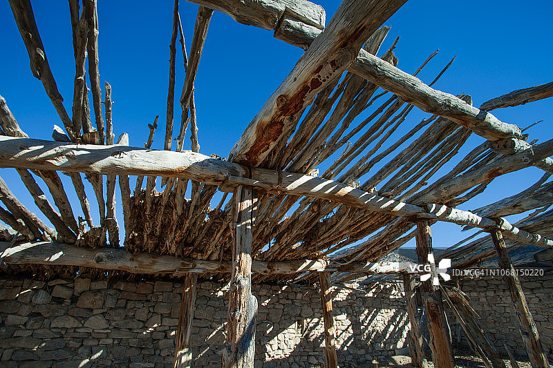 19世纪摇摇欲坠的石墙小木屋，风化的木头和木板屋顶视角图片素材