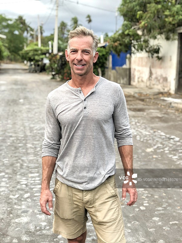 在第三世界国家鹅卵石路上站立的50多岁身材健壮的男人图片素材