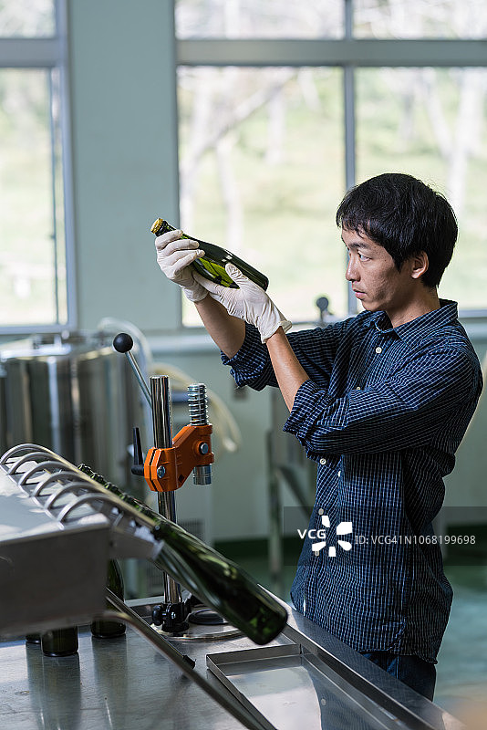 在小型精酿啤酒厂检查最终产品的中年男人图片素材