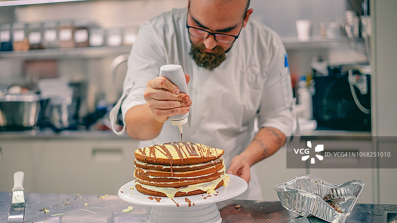 厨师将巧克力酱淋在裸蛋糕上图片素材