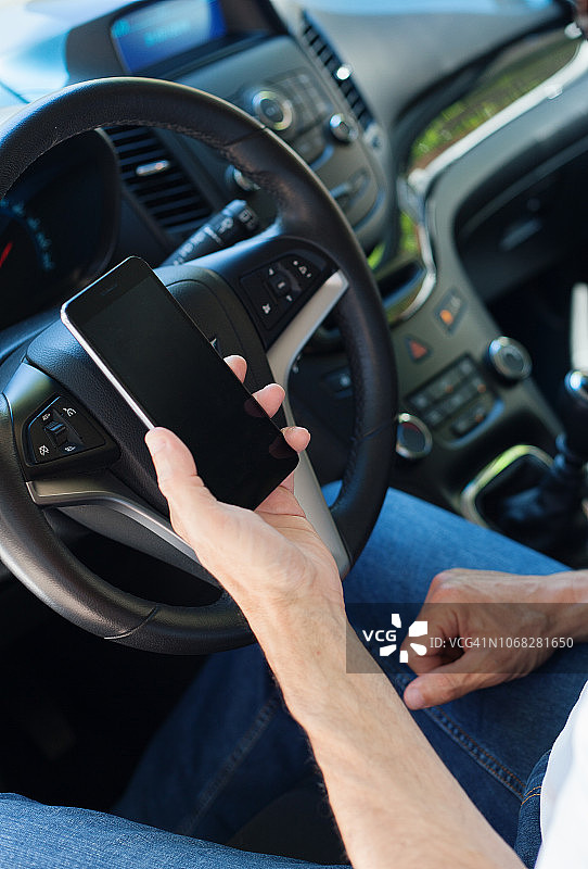 男人在车里看智能手机图片素材