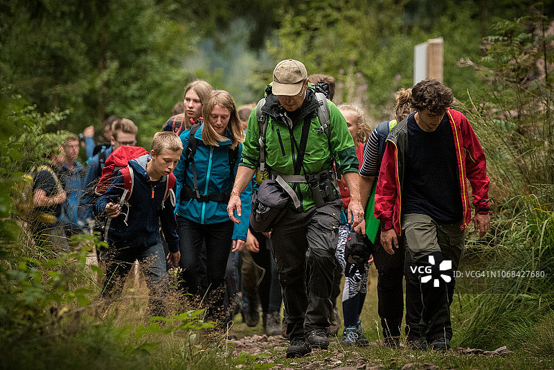 年轻探险者在森林中跟随领队图片素材