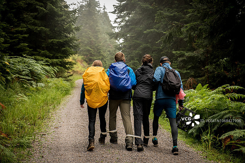 一群青少年在森林里享受三人绑腿赛跑图片素材