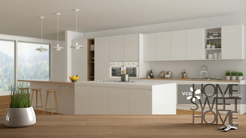 木桌、书桌或搁板，带有盆栽草本植物、房屋钥匙和3D字母（组成温馨的家），位于现代木制厨房内，室内设计，模糊背景图片素材