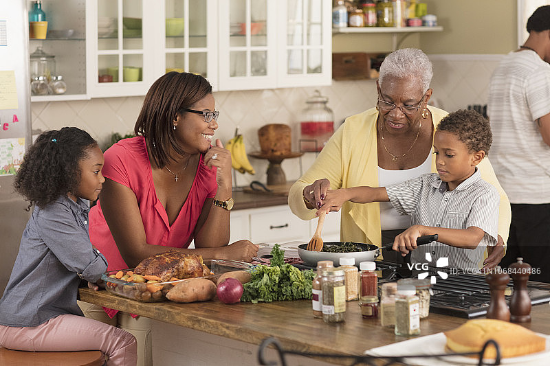 多代同堂家庭在厨房里玩耍图片素材