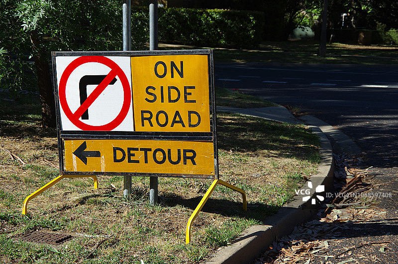 草地路肩上的禁止右转与绕行标志牌图片素材