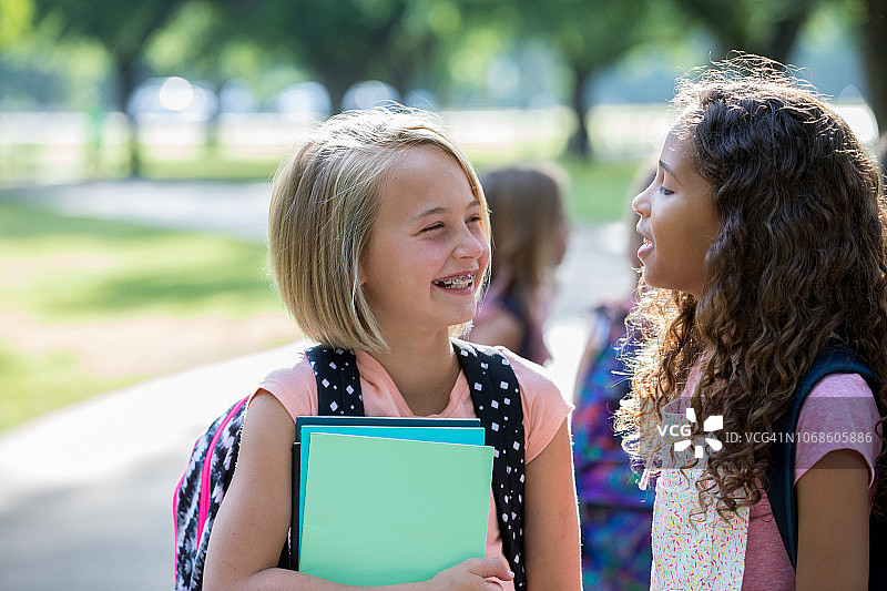 小学生站在学校外面聊天图片素材