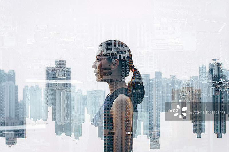 自信的女商人在城市景观上的双重曝光图片素材