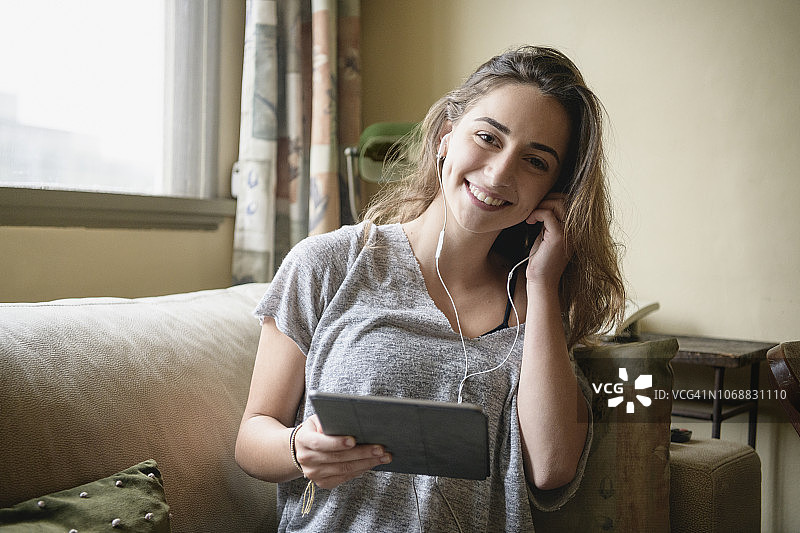 戴着耳机使用平板电脑的女孩图片素材