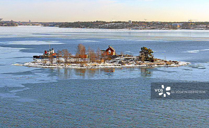 阳光明媚的春天，赫尔辛基群岛中带木屋的岩石岛屿，芬兰图片素材