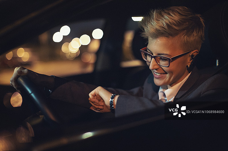 年轻女商人晚上开车图片素材