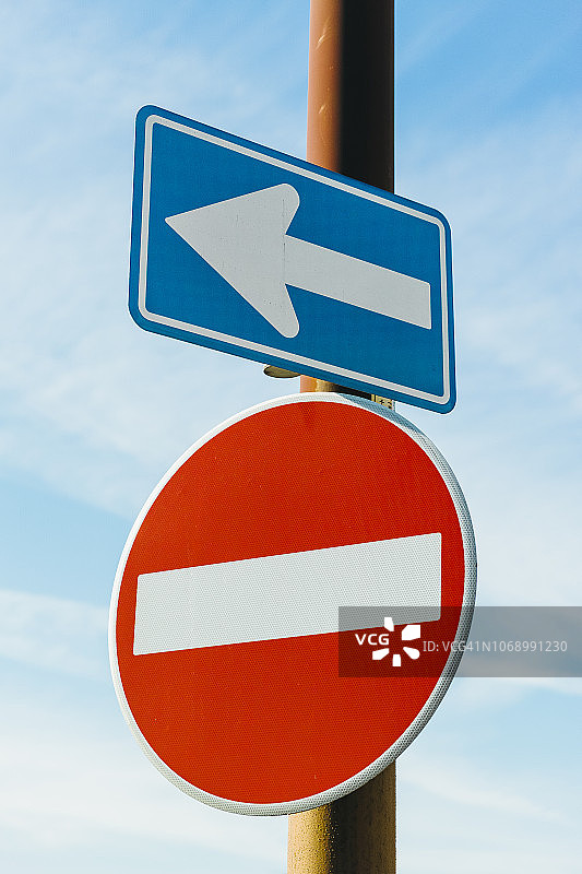 蓝色天空背景上向左箭头标志和禁止驶入标志图片素材