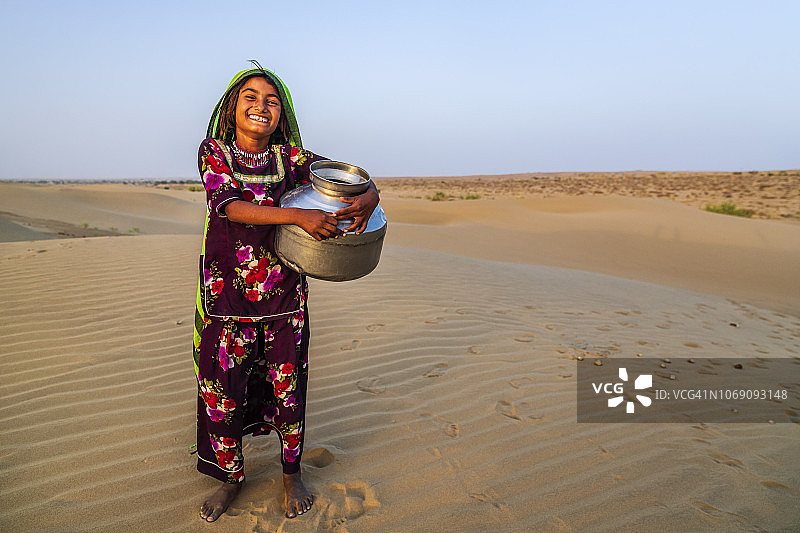 印度沙漠村庄里从井里取水的印度小女孩图片素材