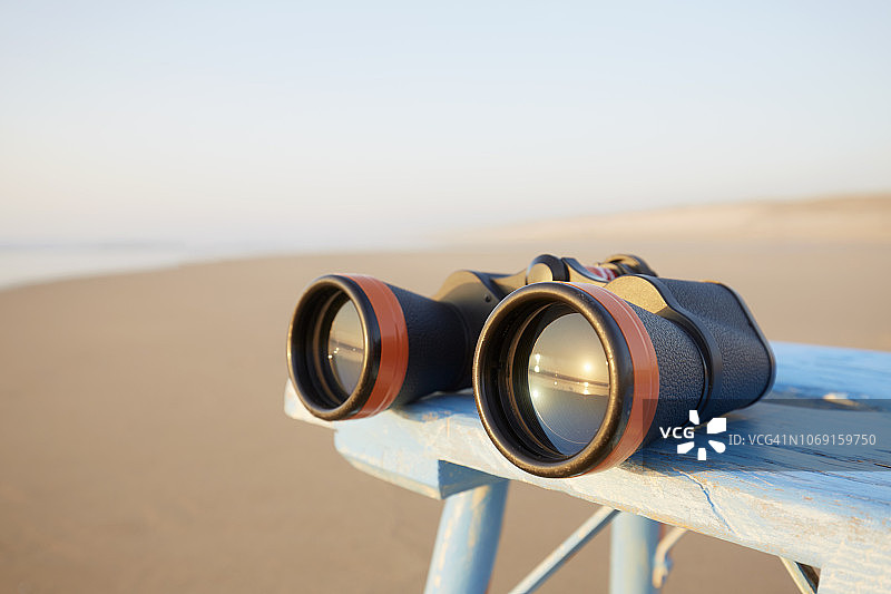 日落时海边桌上的双筒望远镜特写图片素材