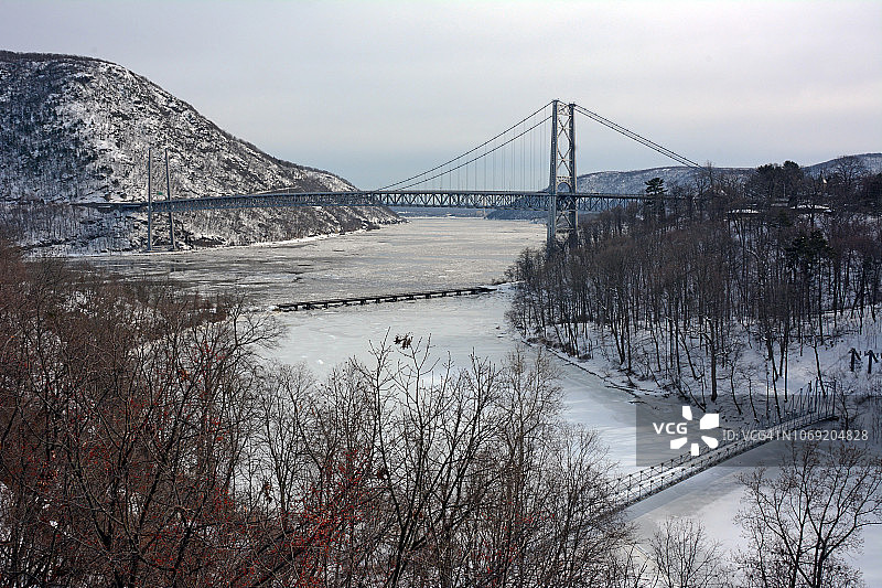 在纽约高地瀑布拍摄的熊山大桥照片，显示了威斯特切斯特县一侧熊山大桥上覆盖着白雪的山脉，以及波波洛彭溪和哈德逊河上的冰。照片拍摄于二月星期六图片素材