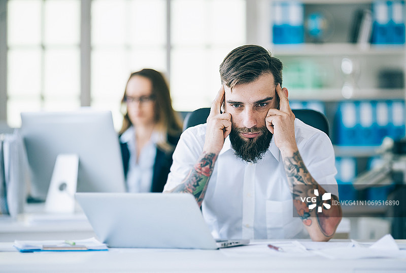 年轻男人在工作中遇到问题，双手抱头图片素材
