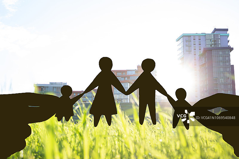手持房屋，绿色田野背景，家庭住宅概念图片素材