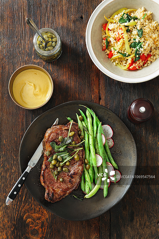 搭配芥末酱、蔬菜、香草和刺山柑的牛排图片素材