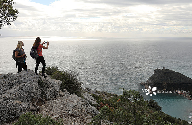 女士们徒步前往海边高地，海岸线图片素材