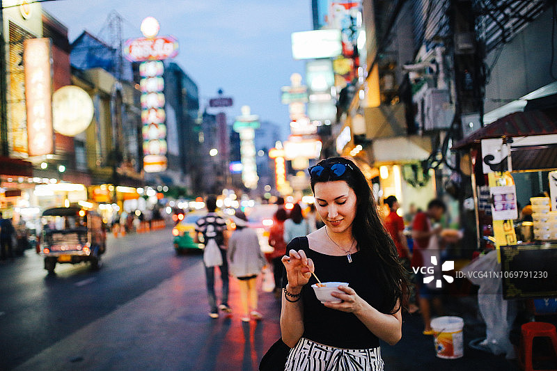 年轻女人在泰国曼谷唐人街吃炸虾天妇罗图片素材