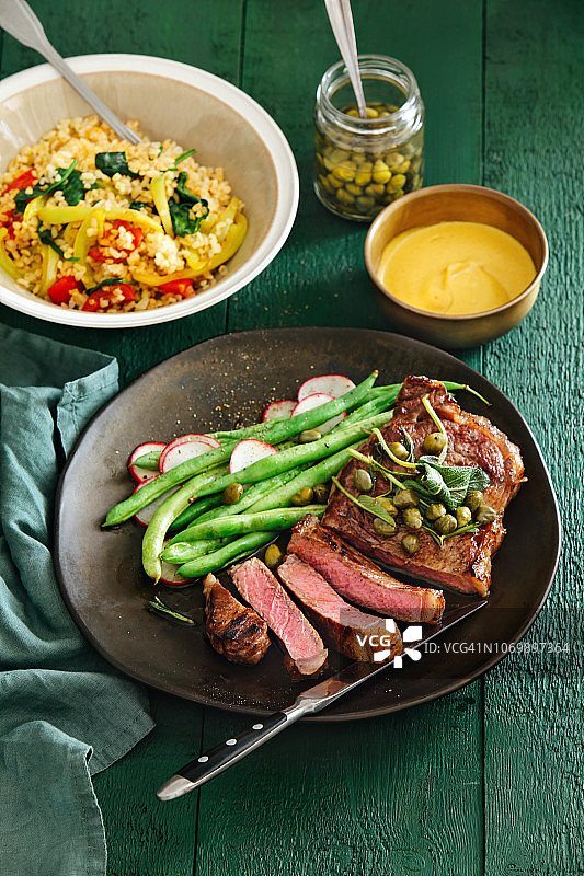 搭配芥末酱、蔬菜、香草和刺山柑的牛排图片素材