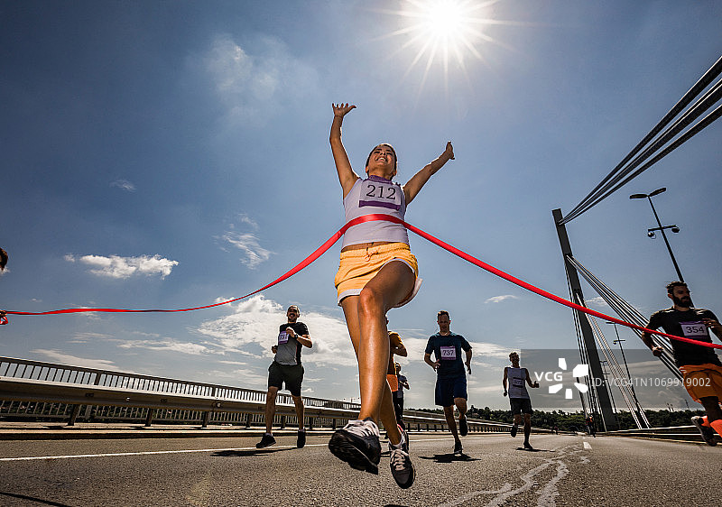 成功的马拉松运动员冲过终点线图片素材