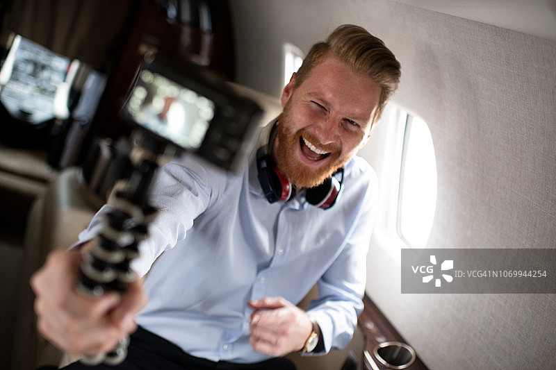 在私人飞机上自拍的年轻有为的男人图片素材