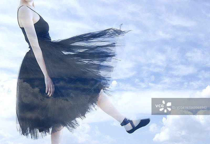 芭蕾舞演员和多云天空的双重曝光图片素材