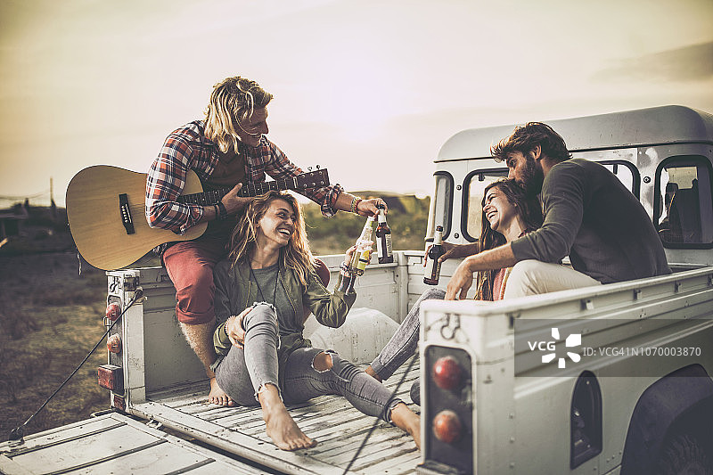夕阳下皮卡车中幸福情侣举杯庆祝图片素材