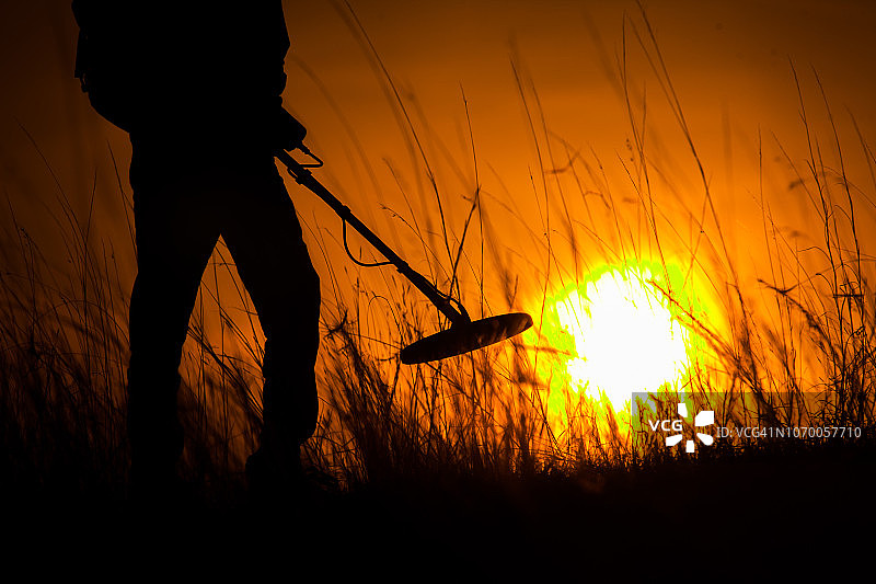 用金属探测器寻找宝藏的人的轮廓图片素材