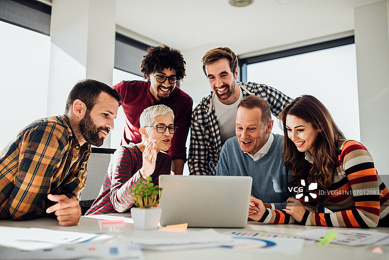 微笑的人们在使用笔记本电脑图片素材