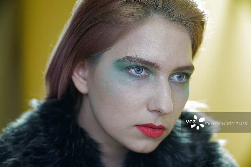 粉色头发、深绿色眼影和亮红色哑光唇膏的年轻女人图片素材